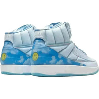 Jordan x J Balvin Air Jordan 2 in light blue with cloud heel graphics, rainbow stitching, and a yellow smiley face logo.