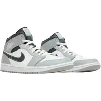 Jordan 1 Mid in Light Smoke Grey and white leather with a black Swoosh, black collar, and white Wings logo.