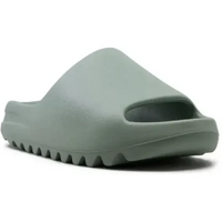 Adidas Yeezy Slide in a monochromatic Salt foam colorway featuring a seamless, minimalist design and serrated outsole.
